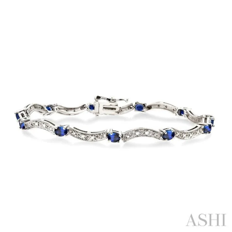 4x3mm Oval Cut Sapphire and 1/10 Ctw Single Cut Diamond Tennis Bracelet in 14K White Gold